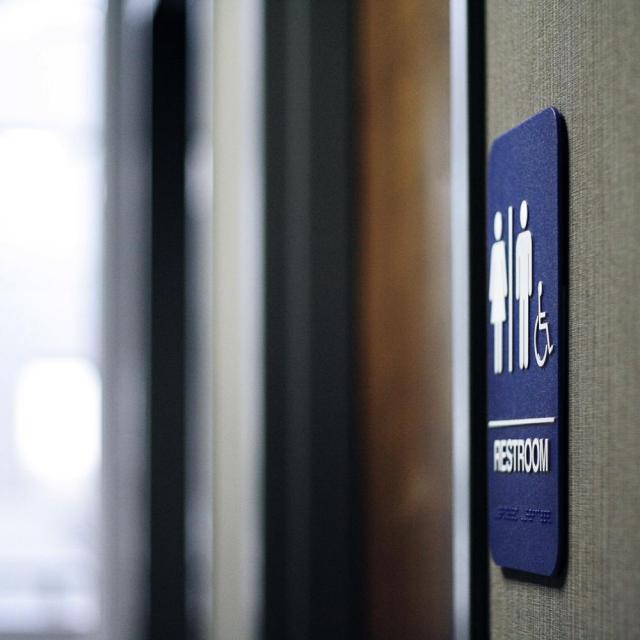 Photo of a restroom sign next to a door