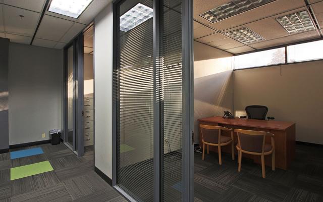 Interior photo of a floor-to-ceiling windowed office from within a hallway in Tower Place