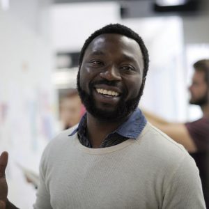 Headshot of a man in casual business attire smiling at the camera